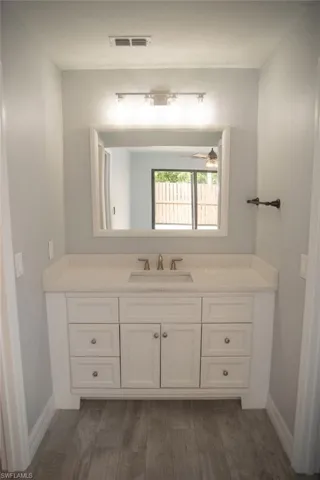 Bathroom with vanity, hardwood / wood-style floors, and ceiling fan