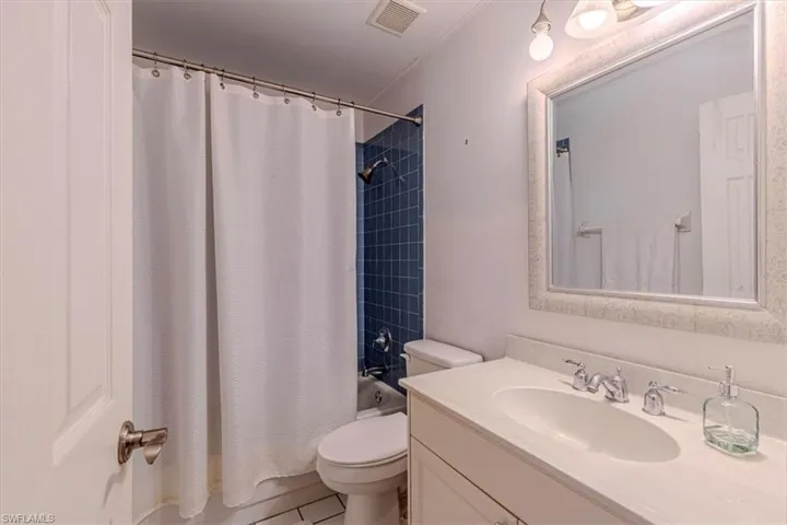 Full bath with shower / bath combo, vanity, and light tile patterned floors