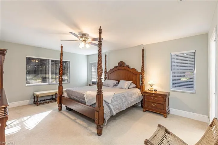 Carpeted bedroom with baseboards and a ceiling fan