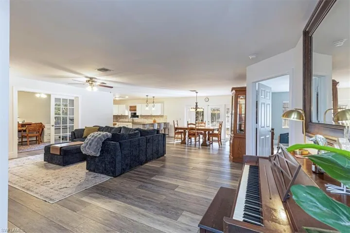 Living area featuring wood finished floors, a chandelier, and ceiling fan