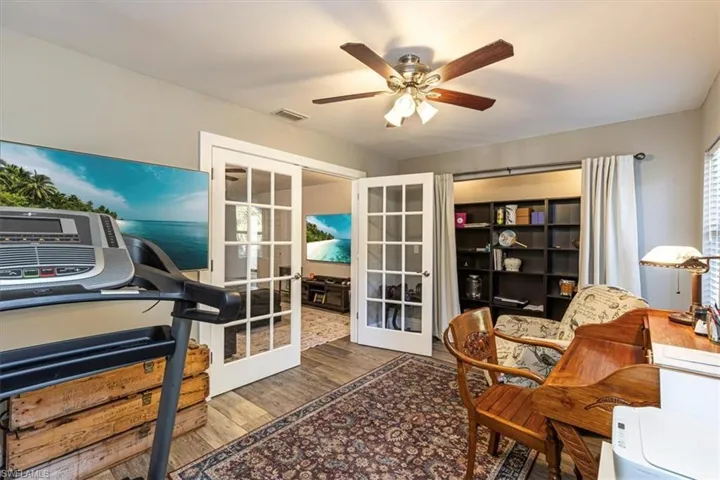 Office space with french doors, wood finished floors, and a ceiling fan
