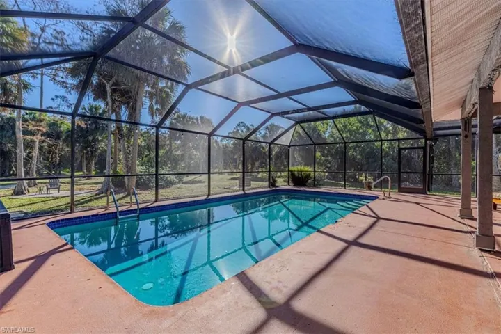 Outdoor pool with a lanai, a sunroom, and a patio area
