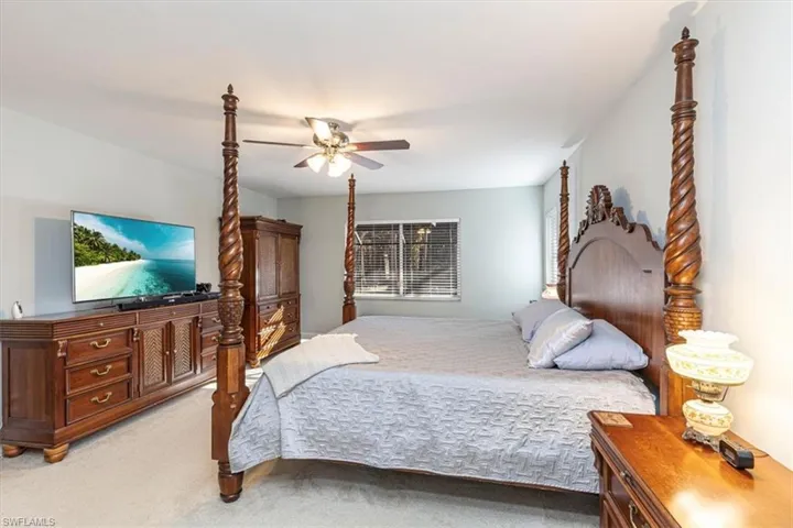 Carpeted bedroom featuring ceiling fan