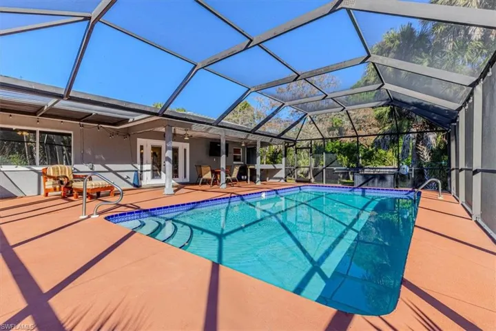 Swimming pool with a lanai, french doors, and a sunroom