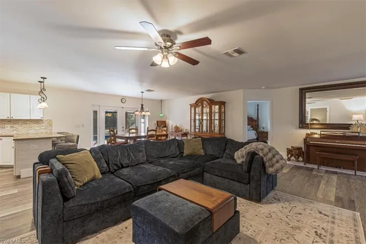 Living area featuring light wood-style flooring, a ceiling fan, and french doors