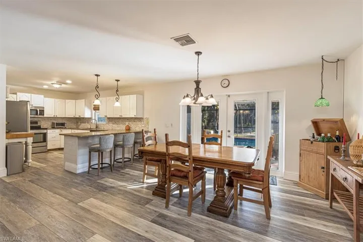 Dining space with french doors, a chandelier, and dark wood finished floors