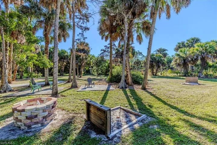 Surrounding community featuring a patio, a lawn, and view of wooded area