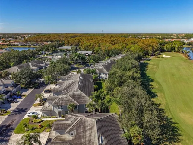 Aerial perspective of suburban area with a large body of water and a golf club