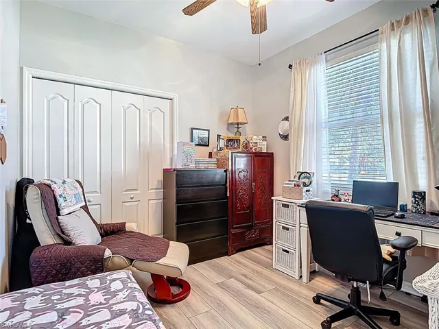 Home office with light wood finished floors and a ceiling fan