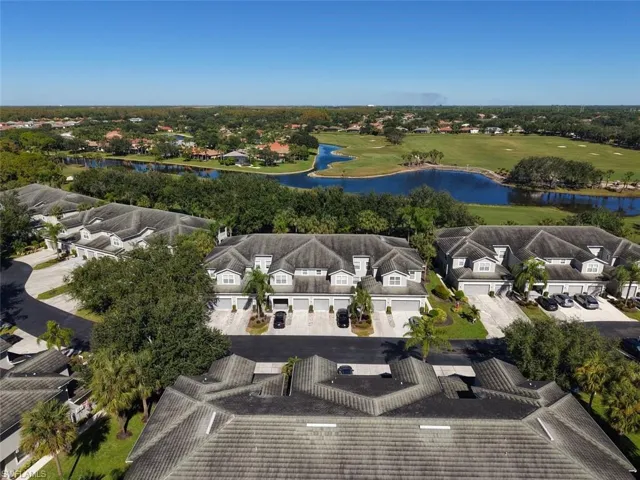 Aerial view of residential area with a nearby body of water and a golf club