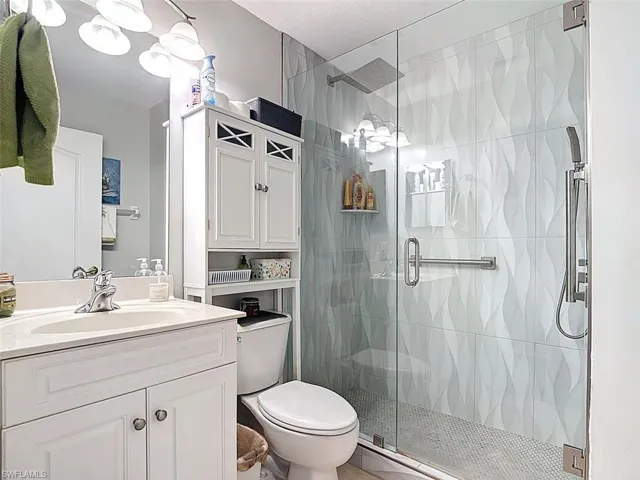 Full bathroom with vanity and a shower stall