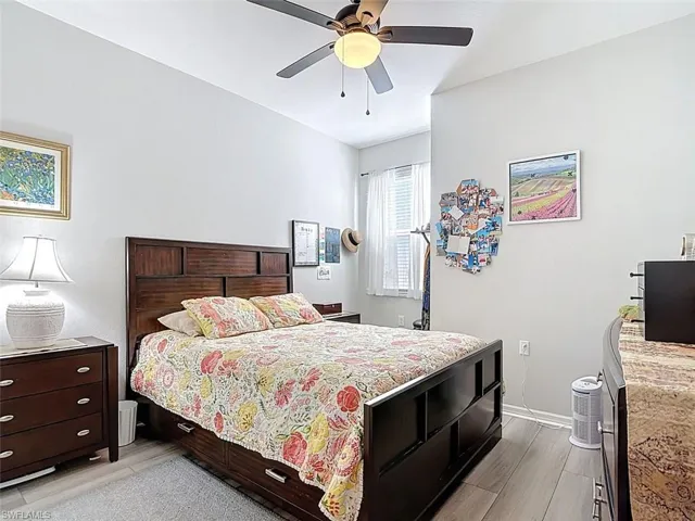 Bedroom with wood tiled floors and a ceiling fan