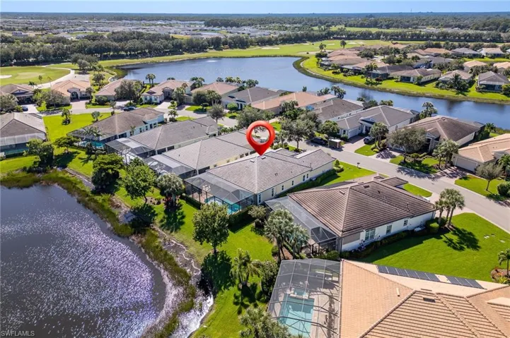 Aerial perspective of a single-story residence featuring a screened-in rear lanai, a built-in swimming pool, a multi-hip roof, and a water-front lot