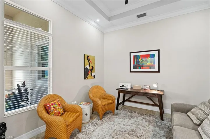 Tray ceiling with crown molding, tall window with transom, and recessed lighting