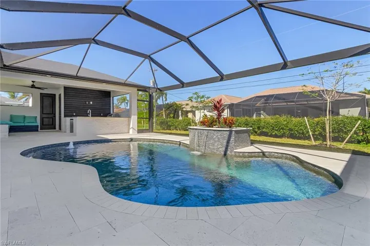 View of swimming pool featuring glass enclosure, pool water feature, ceiling fan, and a patio
