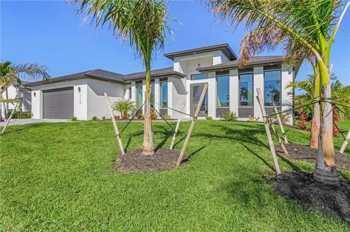 View of front of property with a front lawn and a garage