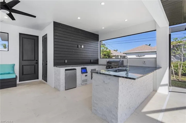 View of patio featuring sink, ceiling fan, a grill, and exterior kitchen