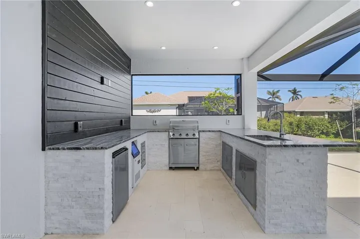 View of patio / terrace with an outdoor kitchen, a grill, and sink