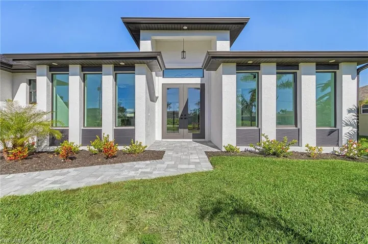 Back of property with a yard and french doors