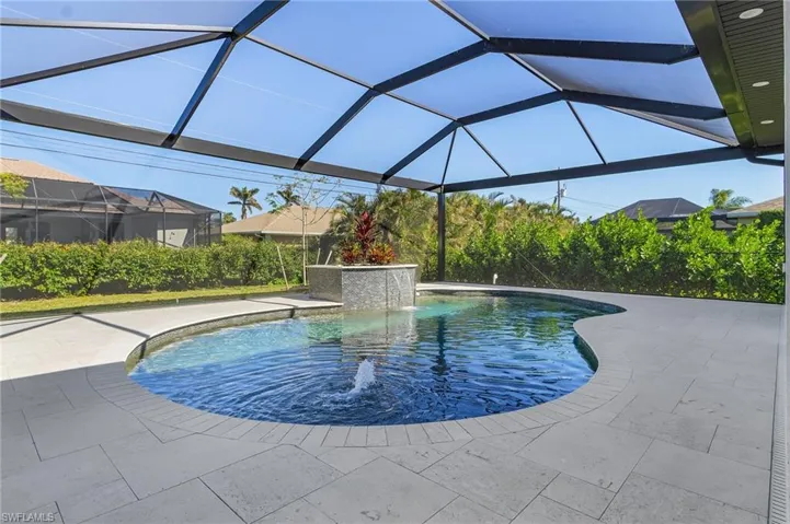 View of pool featuring pool water feature, glass enclosure, and a patio