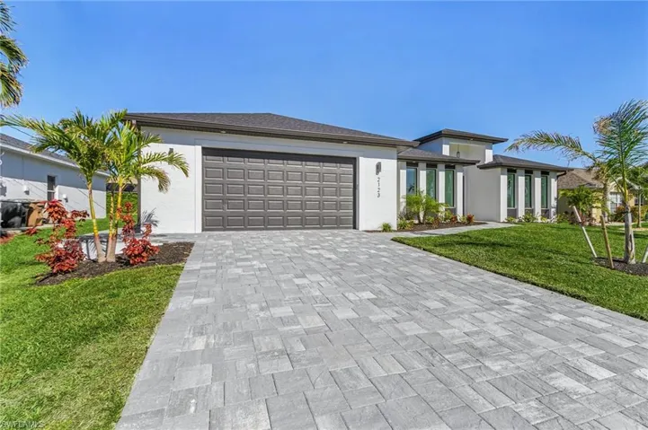 View of front of house with a garage and a front lawn
