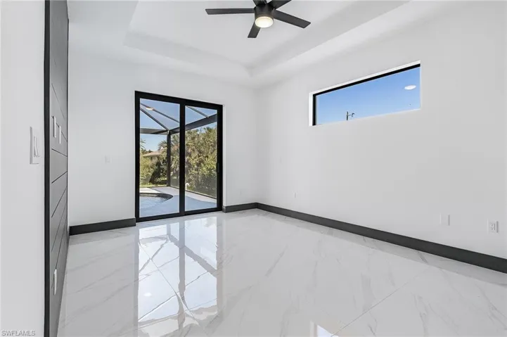 Empty room with a raised ceiling and ceiling fan