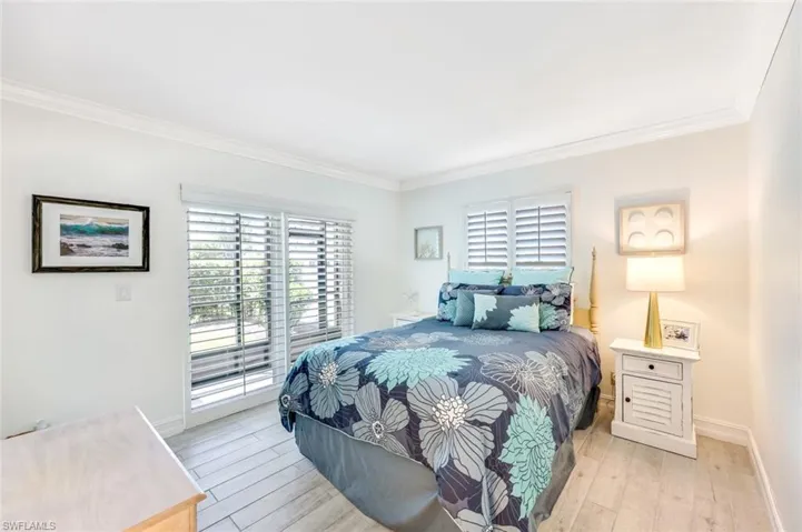Bedroom with crown molding, access to outside, and hardwood / wood-style floors