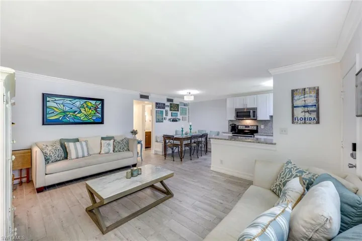 Living area featuring crown molding and light wood-style floors