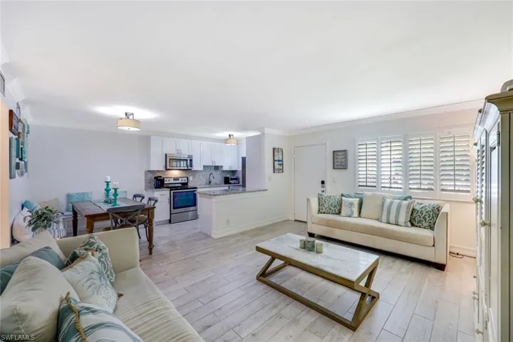Living area featuring ornamental molding and light wood finished floors
