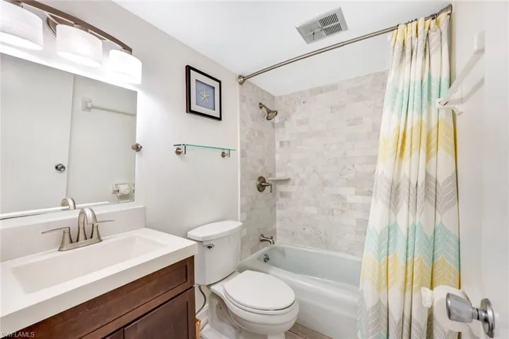 Full bathroom featuring shower / bath combo with shower curtain and vanity