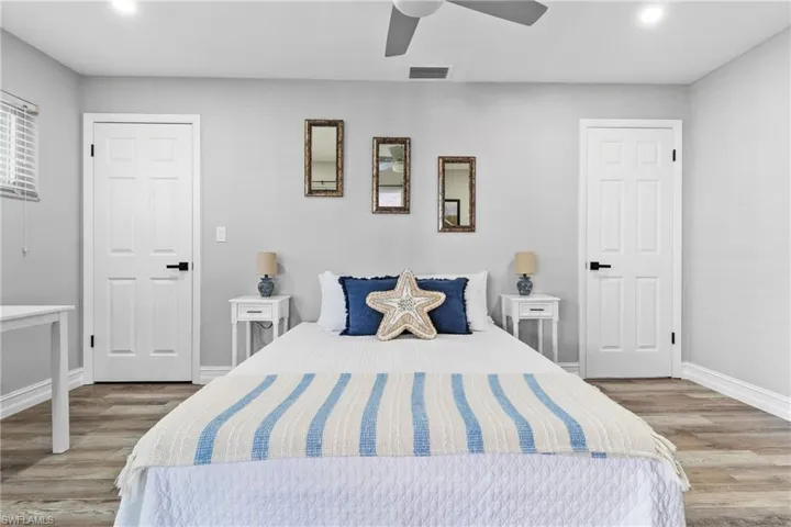 Bedroom featuring baseboards, ceiling fan, visible vents, and wood finished floors