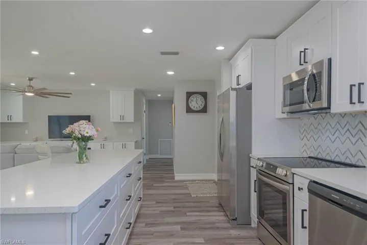 Kitchen with white cabinetry, stainless steel appliances, and tasteful backsplash