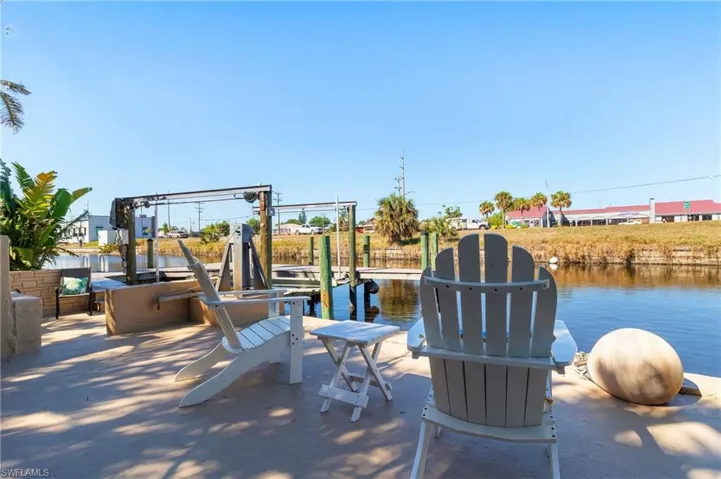 View of patio with boat lift and a boat dock