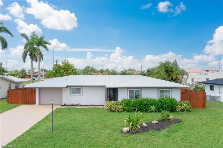 Single story home with a garage and a front lawn