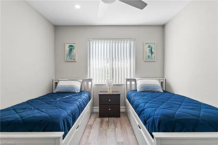 Bedroom featuring baseboards, wood finished floors, recessed lighting, and a ceiling fan