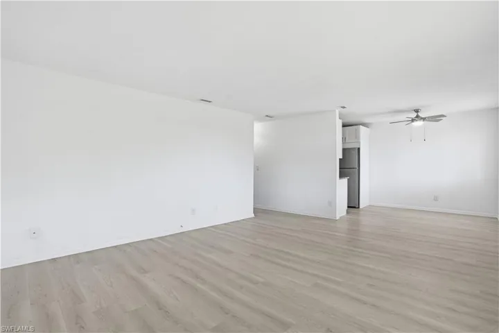 Unfurnished living room featuring a ceiling fan and light wood-style flooring