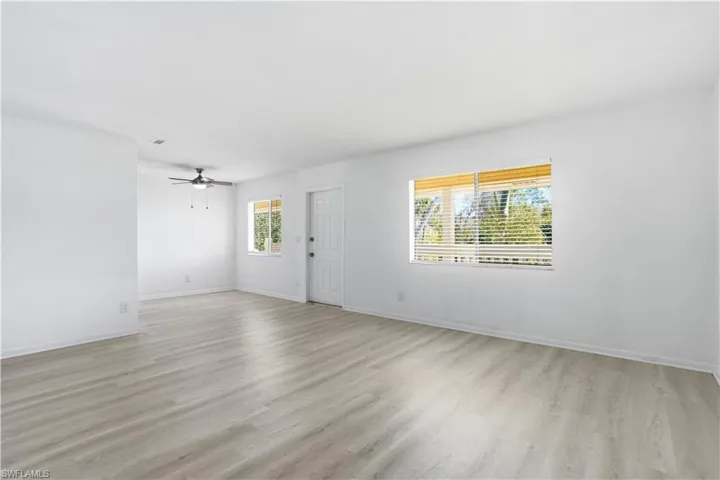 living room with light wood-type flooring and a ceiling fan