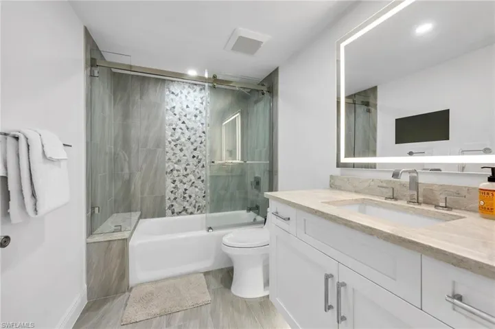 All New Guest en suite Bathroom Featuring Vanity, Bath / Shower Combo w/Glass Doors and Smart Mirror
