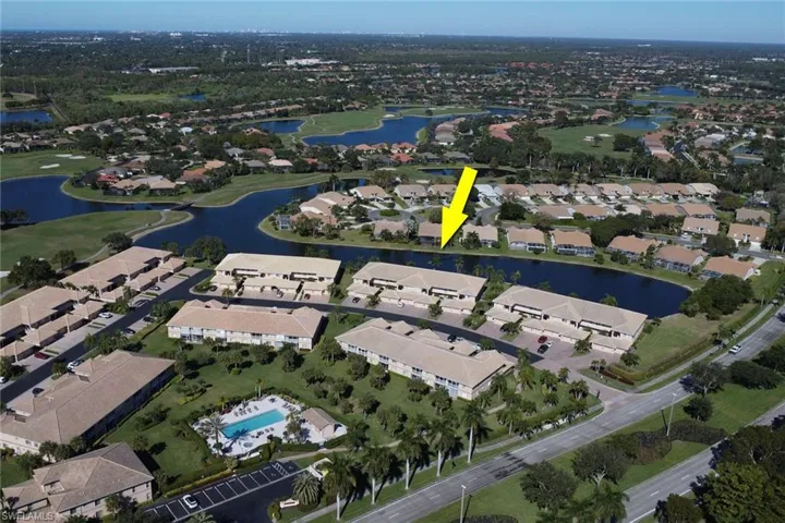 Aerial view of property's location featuring a nearby body of water and nearby suburban area
