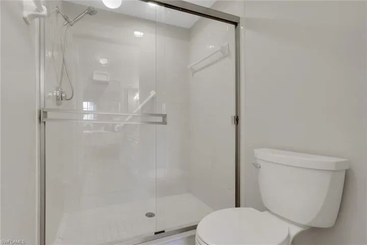 Full bathroom featuring toilet and a shower stall
