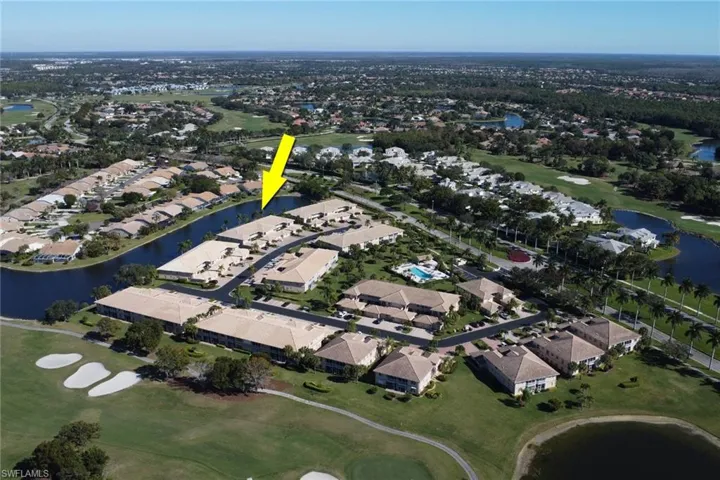 View of property location with a golf club, a large body of water, and nearby suburban area