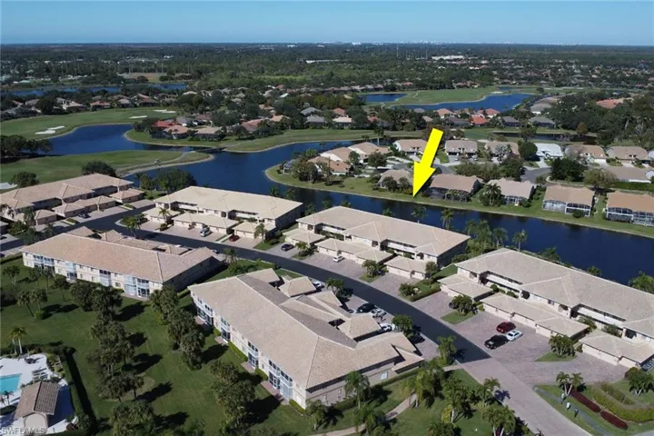 Aerial view of property's location featuring a nearby body of water and nearby suburban area