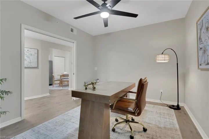 Home office with light wood-style flooring and ceiling fan