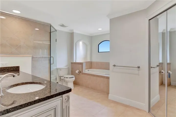 Full bathroom with separate shower and bath, vanity, toilet, crown molding, and walk in closet