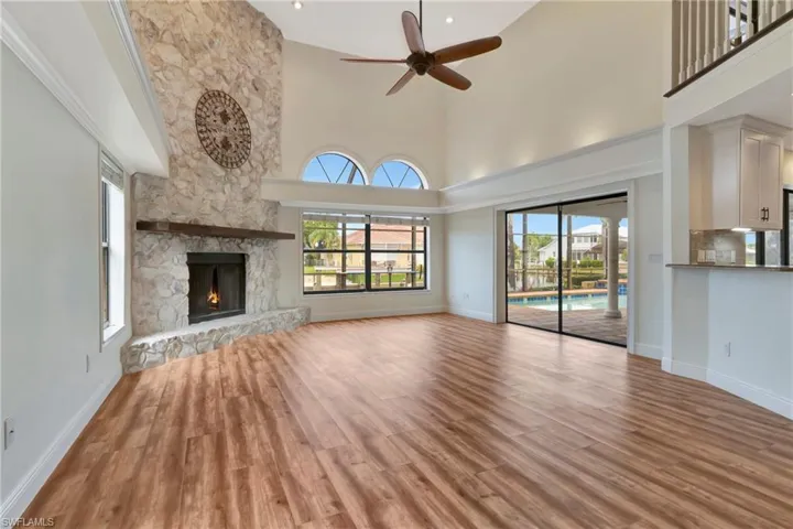 Unfurnished living room with plenty of natural light, a stone fireplace, and light hardwood / wood-style floors