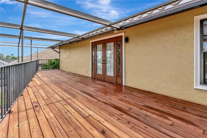 Expansive Wooden balcony featuring french doors