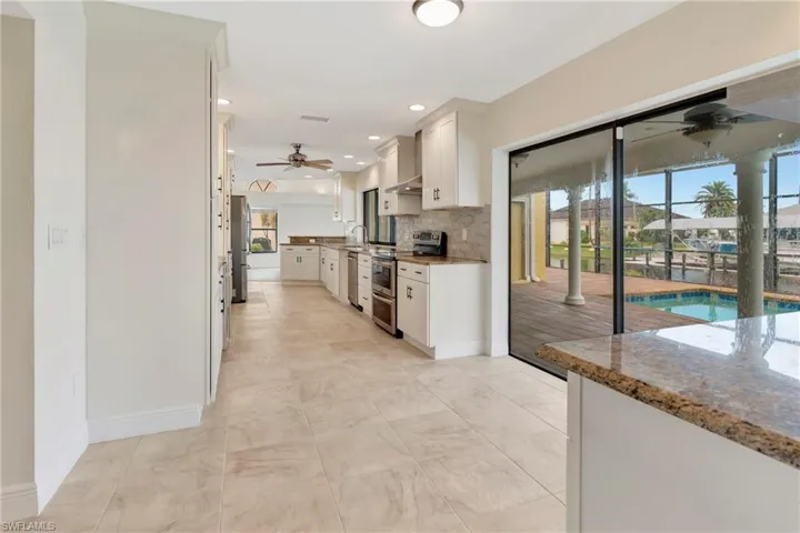 Kitchen featuring white cabinetry, stone countertops, plenty of natural light, and appliances with stainless steel finishes