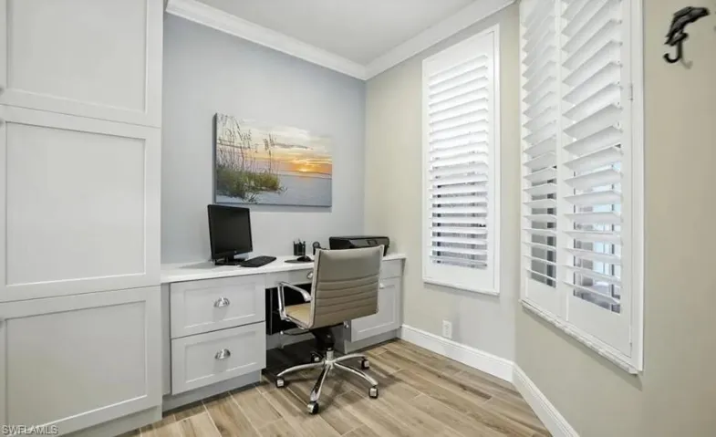 Office with ornamental molding and light wood-style floors