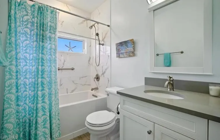 Full bathroom with shower / bath combination with curtain and vanity