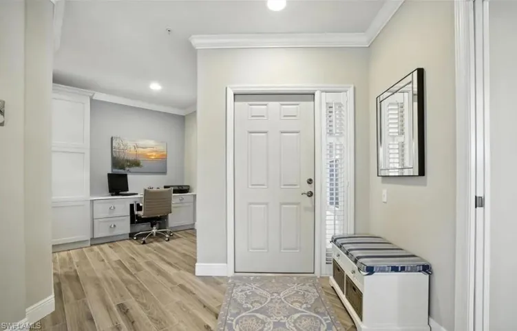 Foyer entrance with crown molding, wood tiled floors, and recessed lighting